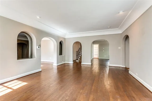 a view of empty room with wooden floor and floor to ceiling window