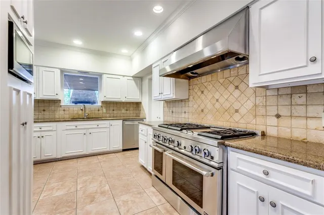a kitchen with stainless steel appliances granite countertop a stove and a sink