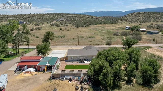 an aerial view of a house with a mountain
