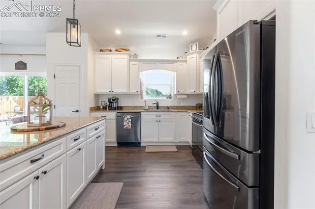 a kitchen with a refrigerator sink and cabinets