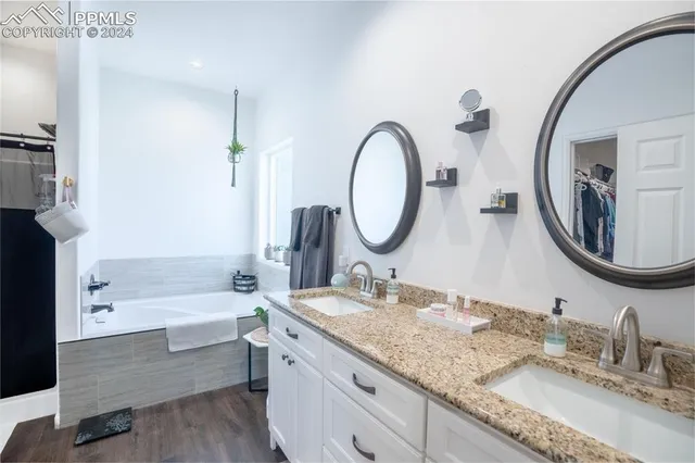 a bathroom with a granite countertop sink mirror and bathtub