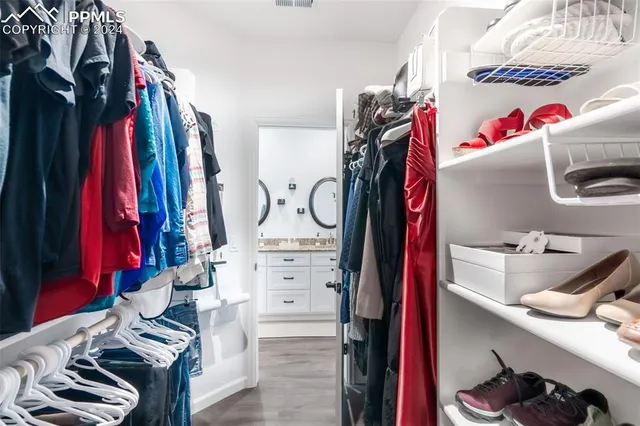 a view of walk in closet with clothes