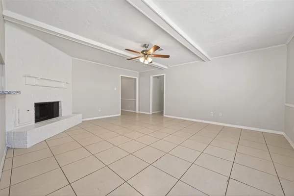 an empty room with fireplace and fan