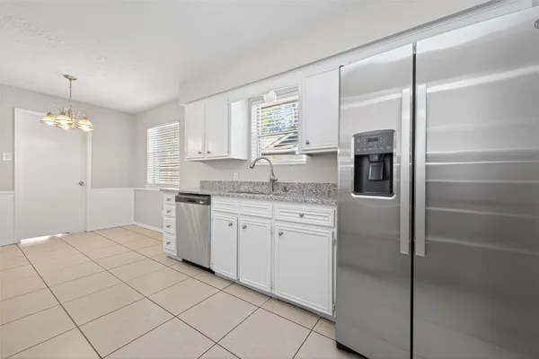 a kitchen with a sink refrigerator and window