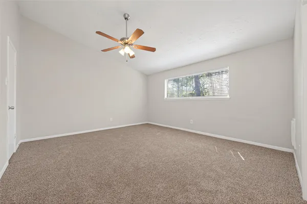 an empty room with windows and fan