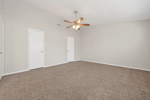 an empty room with a window and a fan