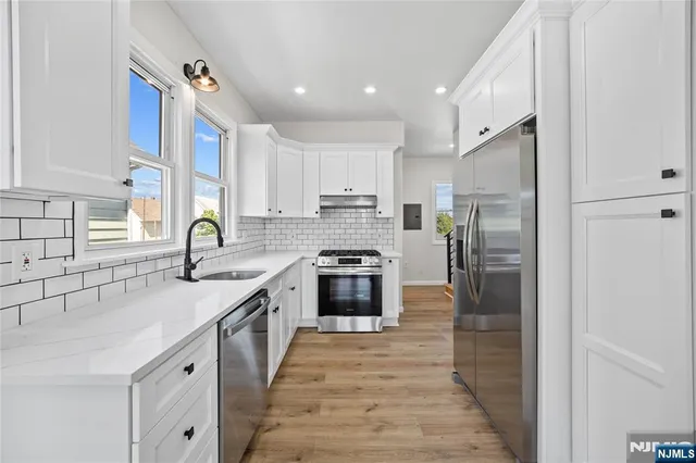 a kitchen with stainless steel appliances granite countertop a stove a sink and a refrigerator