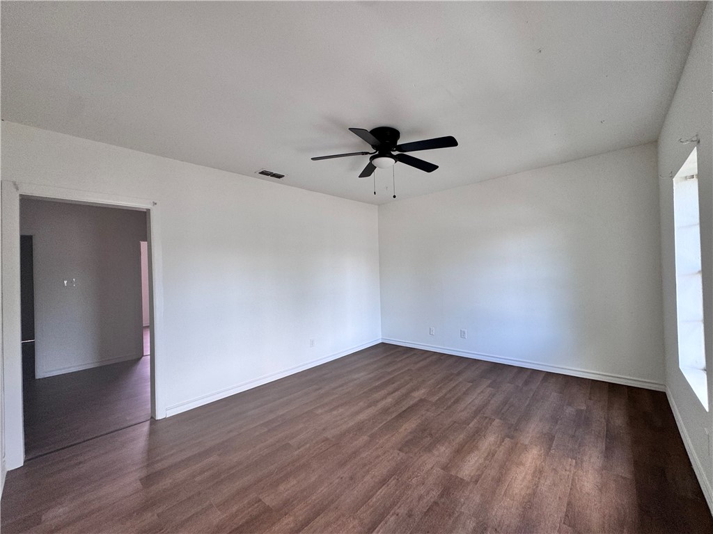 907 Elizabeth Street, Unit 4 Corpus Christi, TX 78404 - Photo 3 of 11 a view of a big room with wooden floor and a ceiling fan