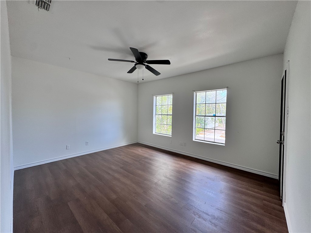 907 Elizabeth Street, Unit 4 Corpus Christi, TX 78404 - Photo 4 of 11 an empty room with wooden floor fan and windows