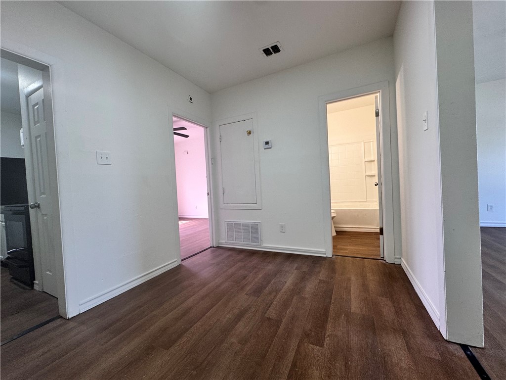 907 Elizabeth Street, Unit 4 Corpus Christi, TX 78404 - Photo 5 of 11 a view of an empty room with wooden floor and a window