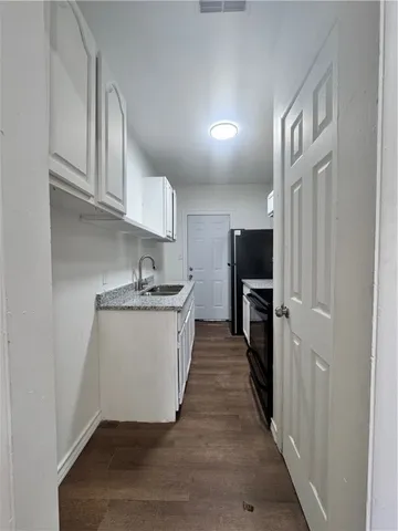 a kitchen with sink a microwave and cabinets