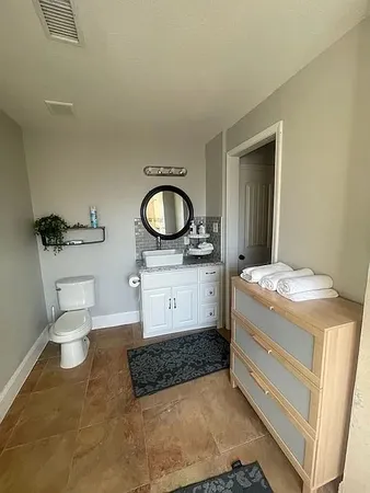 a bathroom with a granite countertop toilet sink and mirror