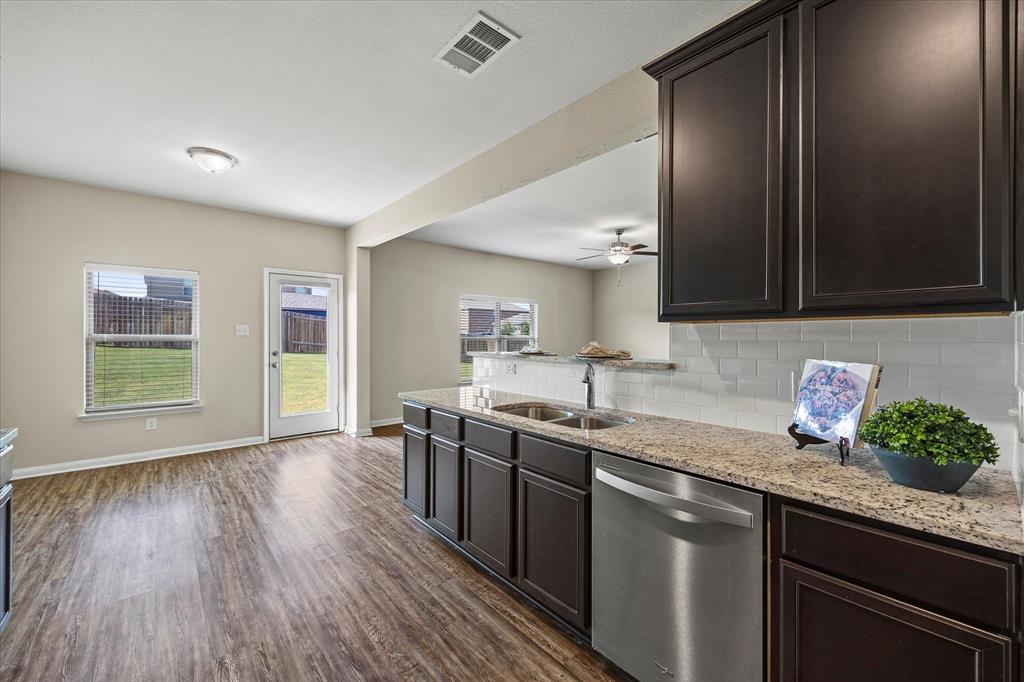 2212 Georgetown Street Princeton, TX 75407 - Photo 10 of 31 a kitchen with granite countertop stainless steel appliances a sink window and cabinets