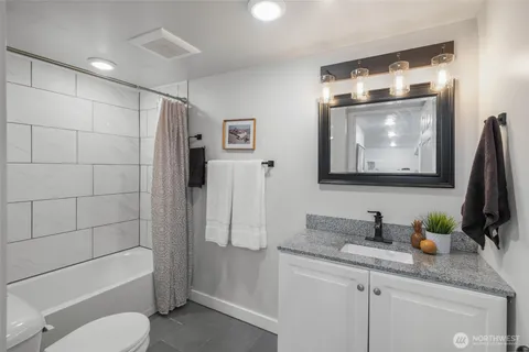 a bathroom with a granite countertop sink toilet and shower