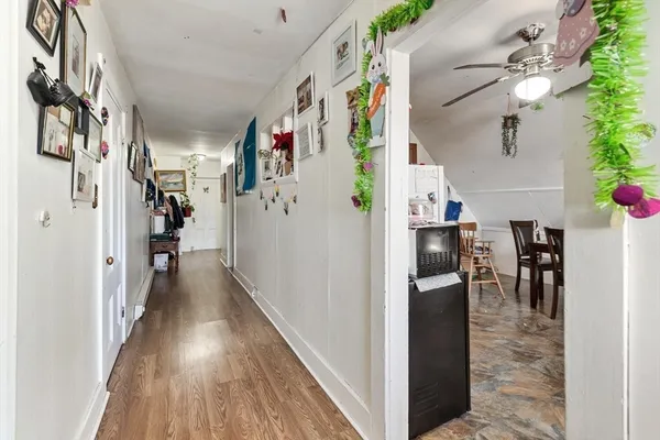 a view of a hallway with furniture and wooden floor