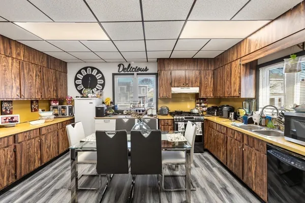 a kitchen with lots of counter top space a sink appliances and cabinets