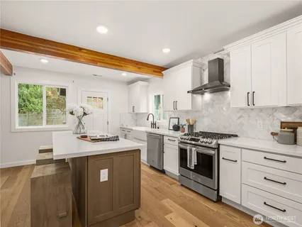 a kitchen with stainless steel appliances granite countertop a sink stove and refrigerator