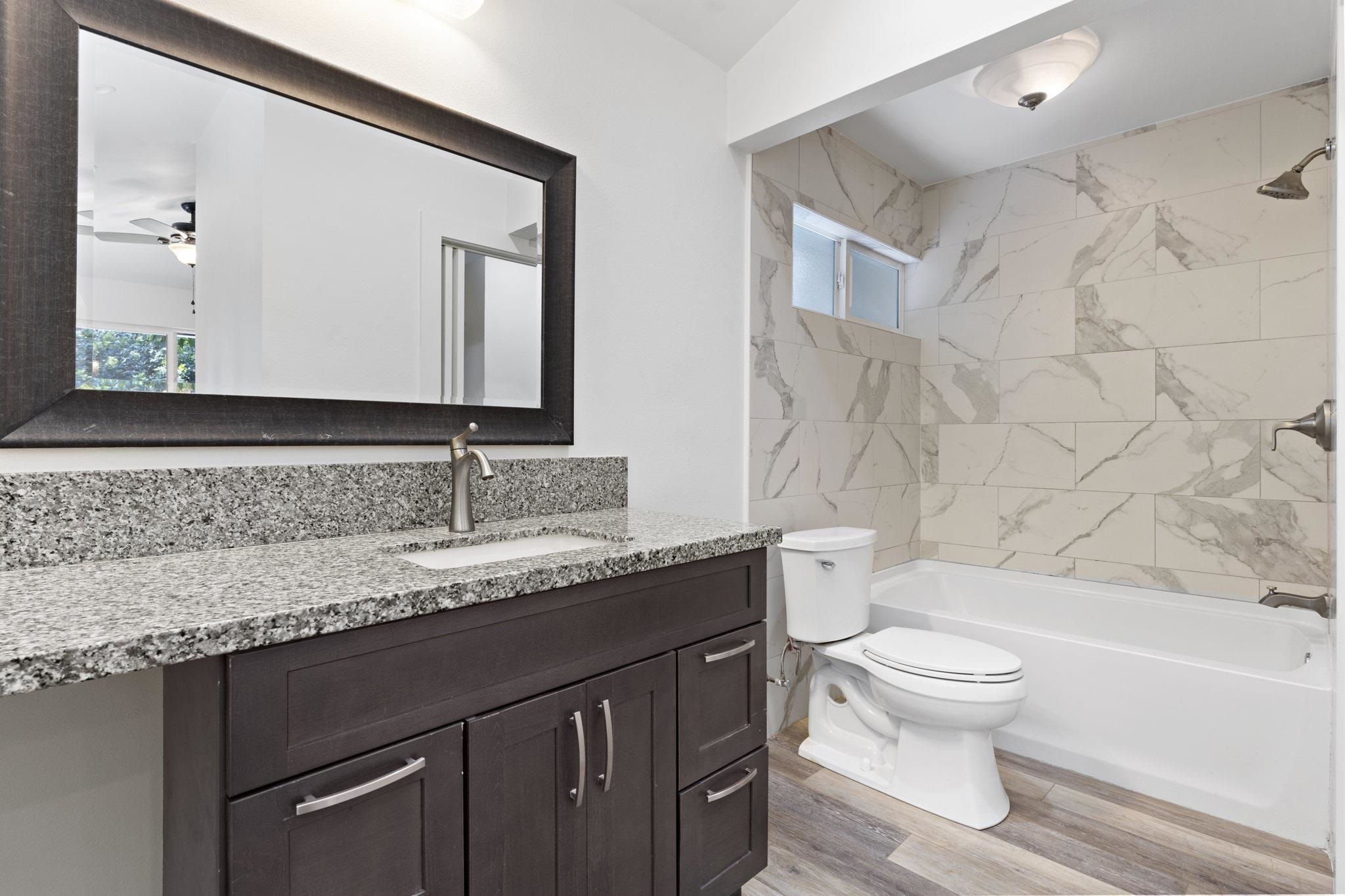14 Kahiapo Place Haiku, HI 96708 - Photo 12 of 30 a bathroom with a granite countertop bathtub sink vanity mirror and toilet