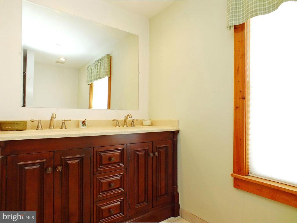19121 Falls Road Hampstead, MD 21074 - Photo 12 of 26 a bathroom with a double vanity sink and a mirror