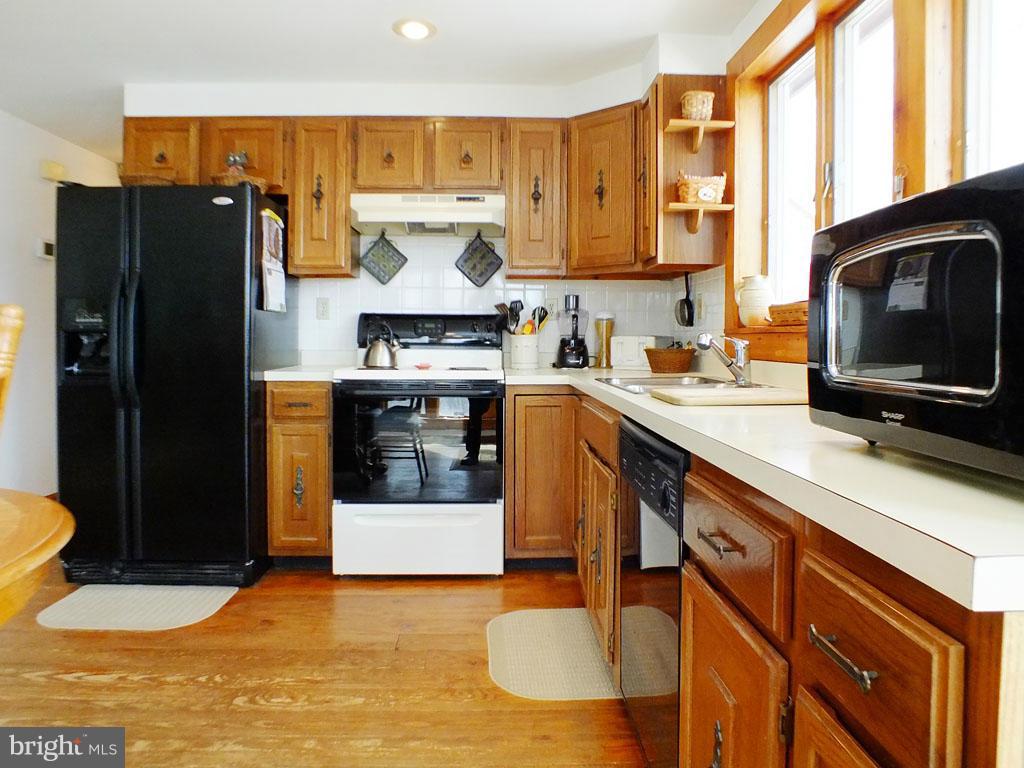 19121 Falls Road Hampstead, MD 21074 - Photo 6 of 26 a kitchen with granite countertop a refrigerator a stove and a sink