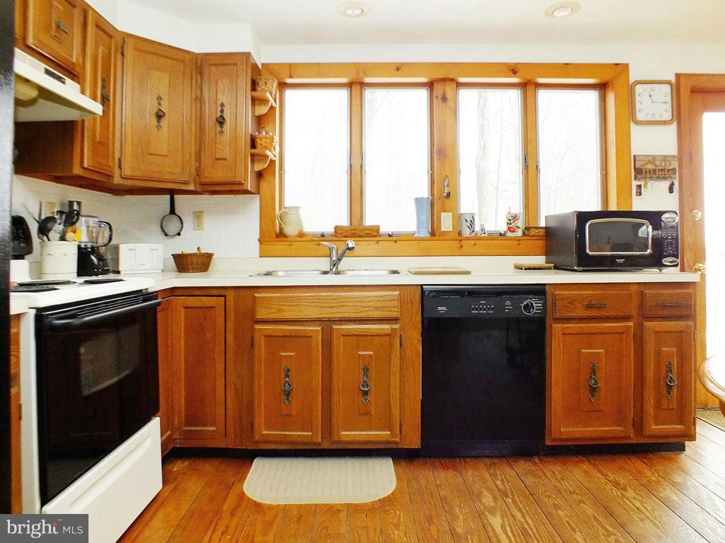 19121 Falls Road Hampstead, MD 21074 - Photo 7 of 26 a kitchen with stainless steel appliances granite countertop a stove a sink and a microwave