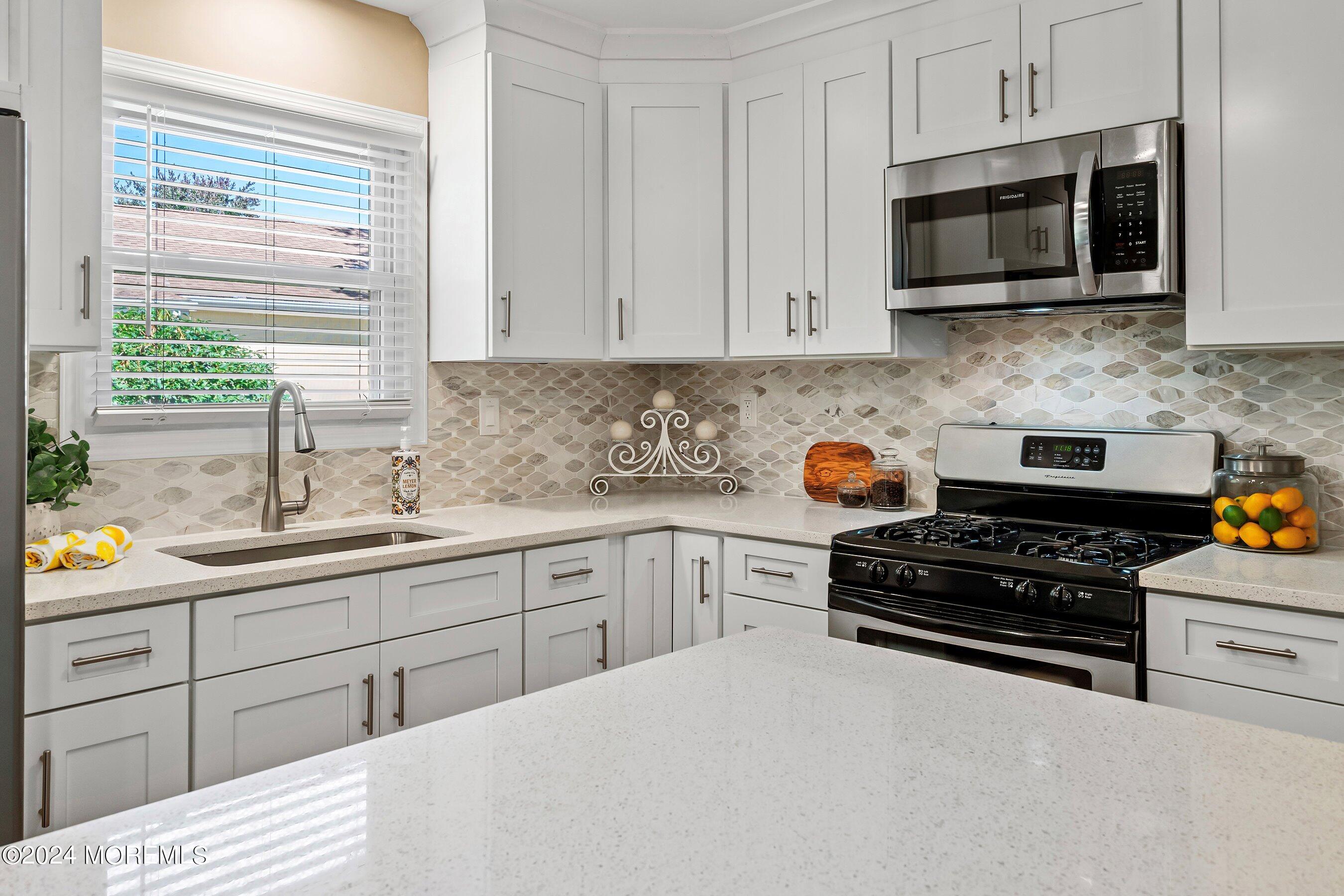 21 Tapola Road Toms River, NJ 08757 - Photo 8 of 22 a kitchen with stainless steel appliances a stove a sink a stove and microwave