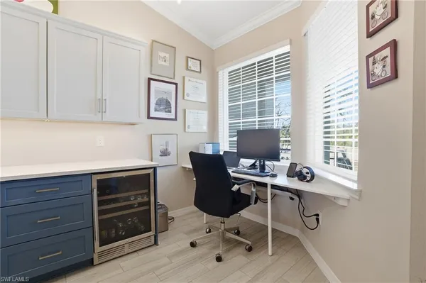 a view of a workspace with furniture and a window