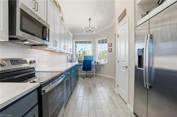 a kitchen with stainless steel appliances a refrigerator and a stove top oven