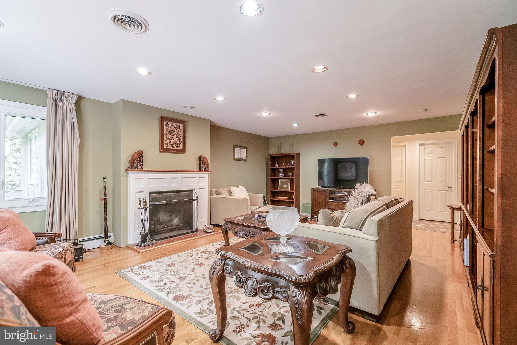 1361 South Leopard Road Berwyn, PA 19312 - Photo 3 of 33 a living room with furniture a fireplace and a flat screen tv