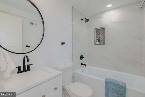 a bathroom with a sink a toilet and a mirror