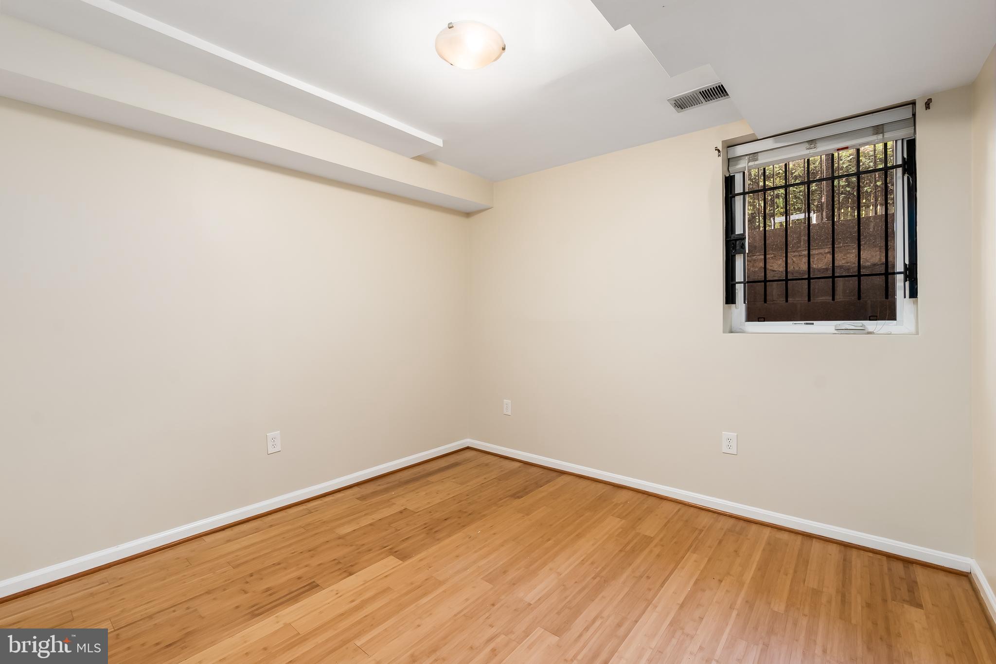 1713 Euclid Street Northwest, Unit 1 Washington, DC 20009 - Photo 10 of 27 a view of an empty room with wooden floor and a window