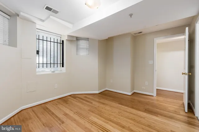 a view of empty room with wooden floor