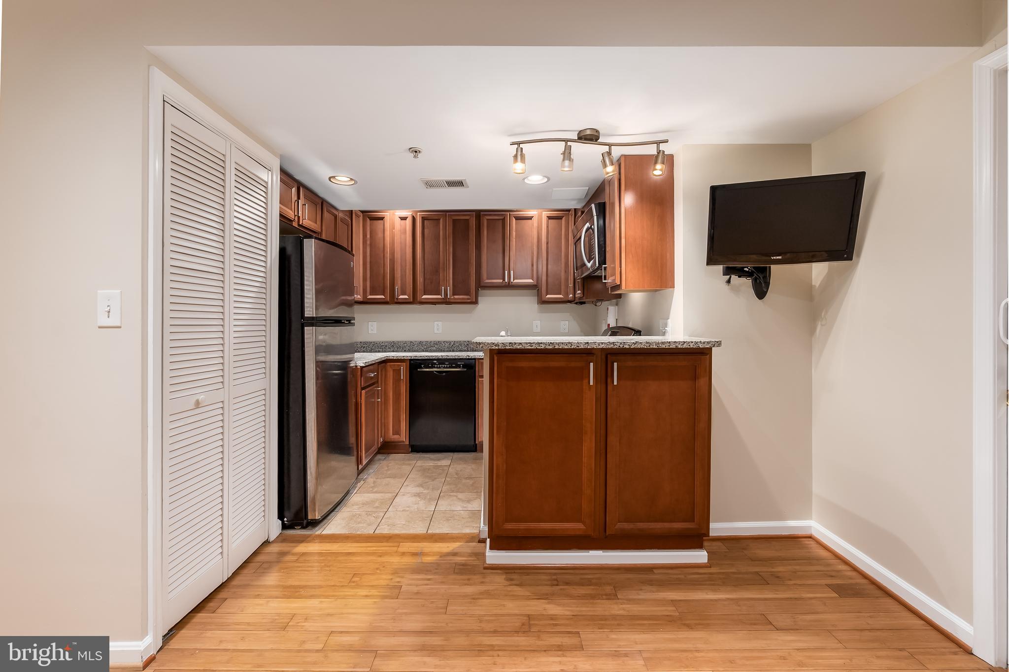 1713 Euclid Street Northwest, Unit 1 Washington, DC 20009 - Photo 6 of 27 a kitchen with kitchen island sink refrigerator and microwave