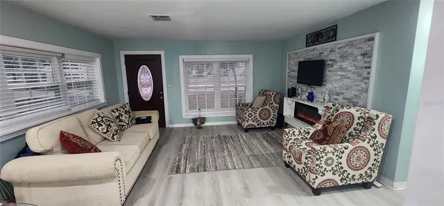 a living room with furniture a flat screen tv and a fireplace