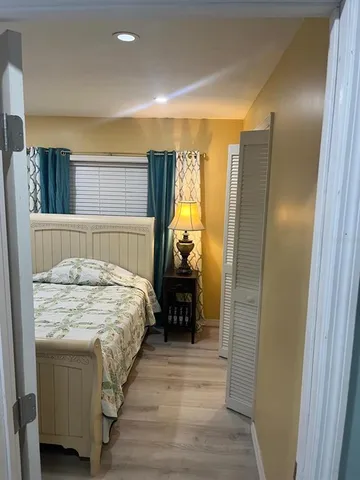 a bedroom with a bed and wooden floor