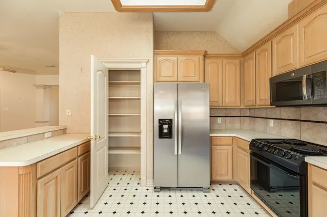 a kitchen with granite countertop a sink cabinets and stainless steel appliances