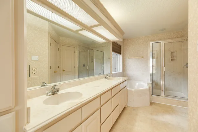 a bathroom with a double vanity sink mirror and a bathtub