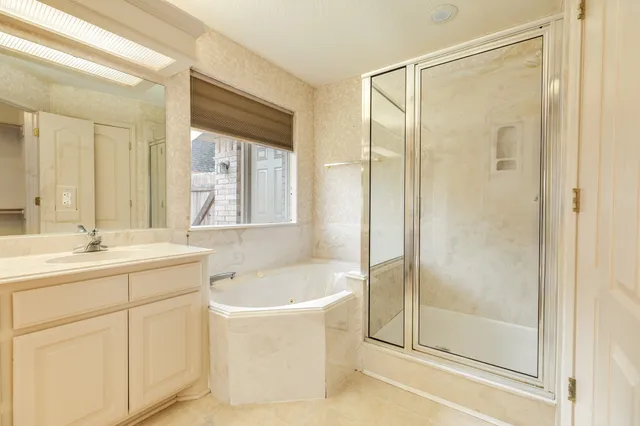 a bathroom with a bathtub shower sink and mirror