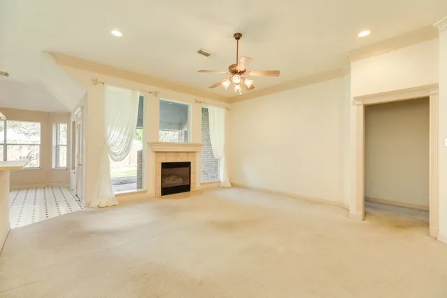 an empty room with windows and fireplace