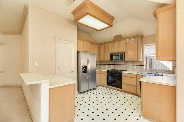 a kitchen with a sink a stove top oven and refrigerator