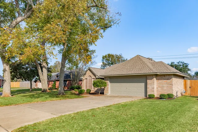a front view of a house with a garden and trees