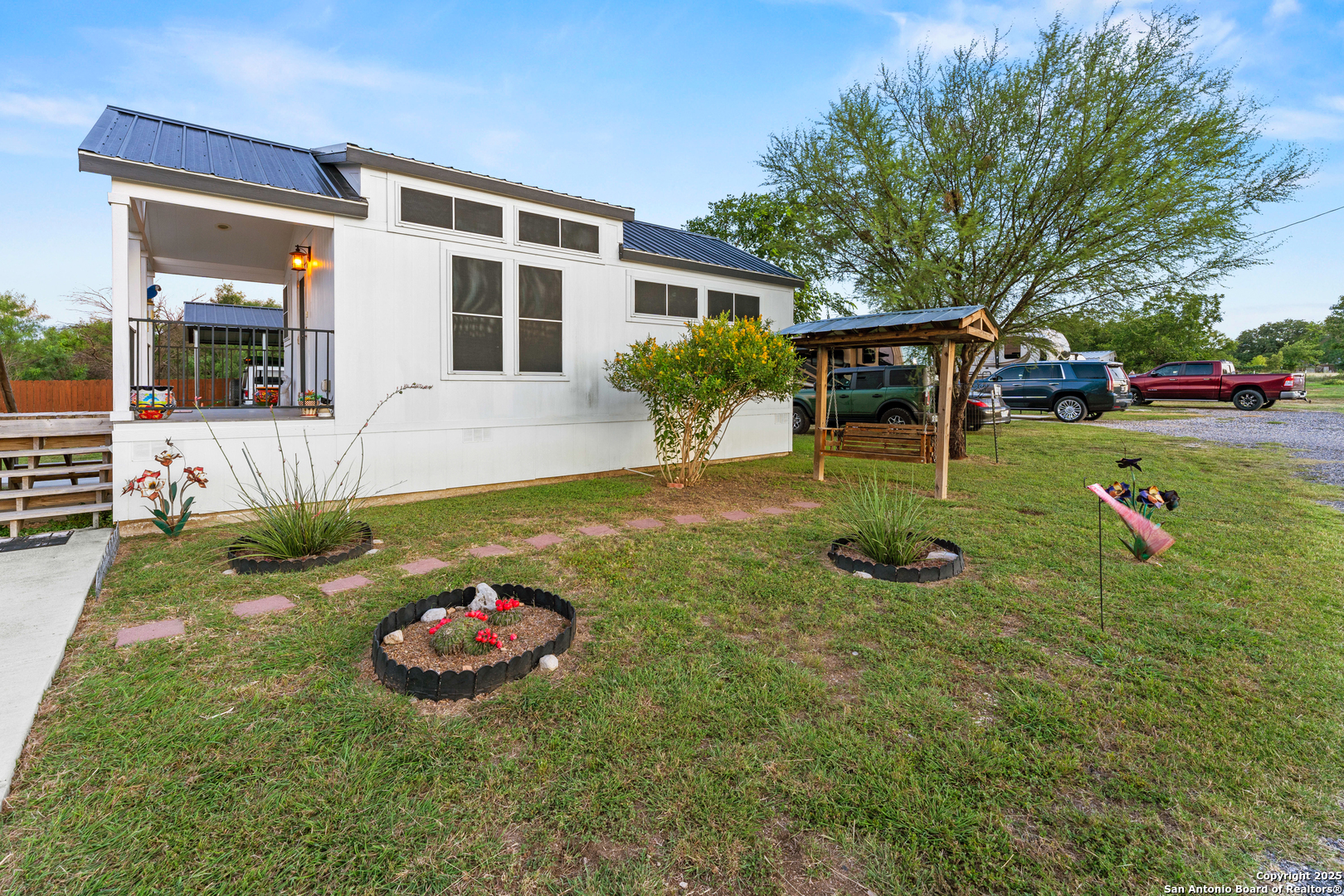 286 Highway 173 Bandera, TX 78003 - Photo 37 of 38 a view of a backyard with table and chairs potted plants and large tree