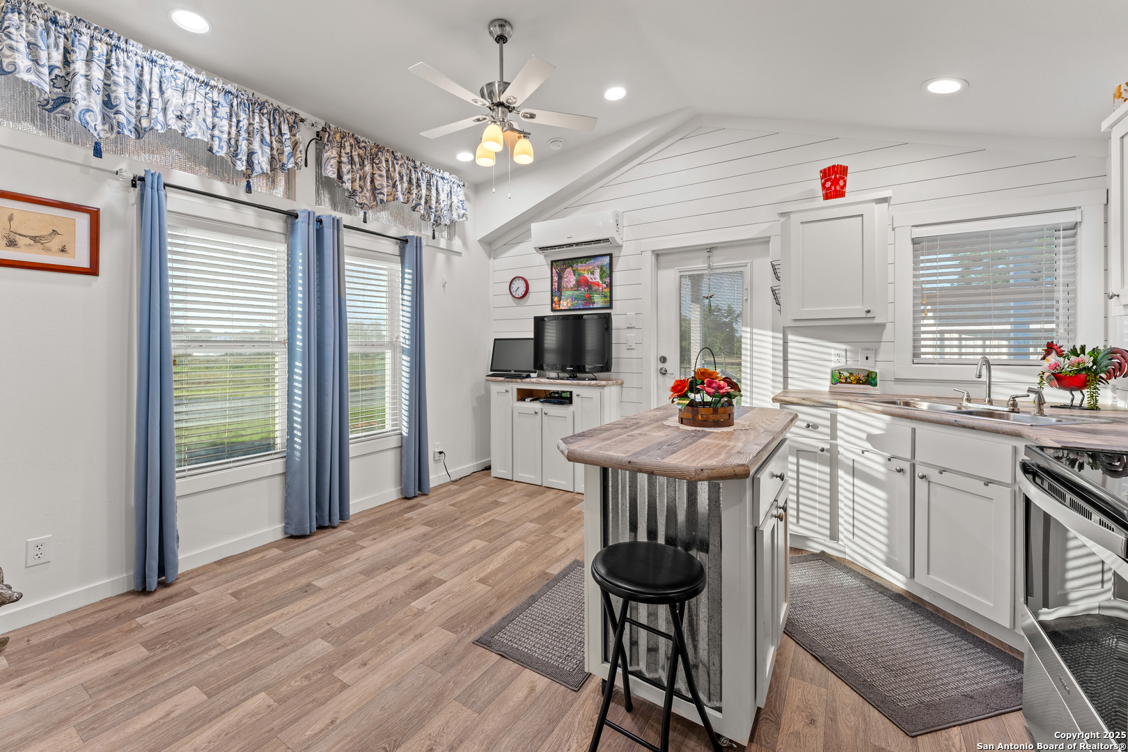 286 Highway 173 Bandera, TX 78003 - Photo 10 of 38 a kitchen with stainless steel appliances kitchen island granite countertop a stove a refrigerator a oven with white cabinets and wooden floor