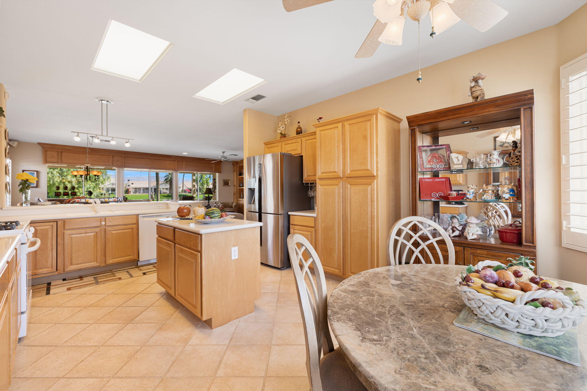 39611 Manorgate Road Palm Desert, CA 92211 - Photo 18 of 45 a large white kitchen with a large window and stainless steel appliances
