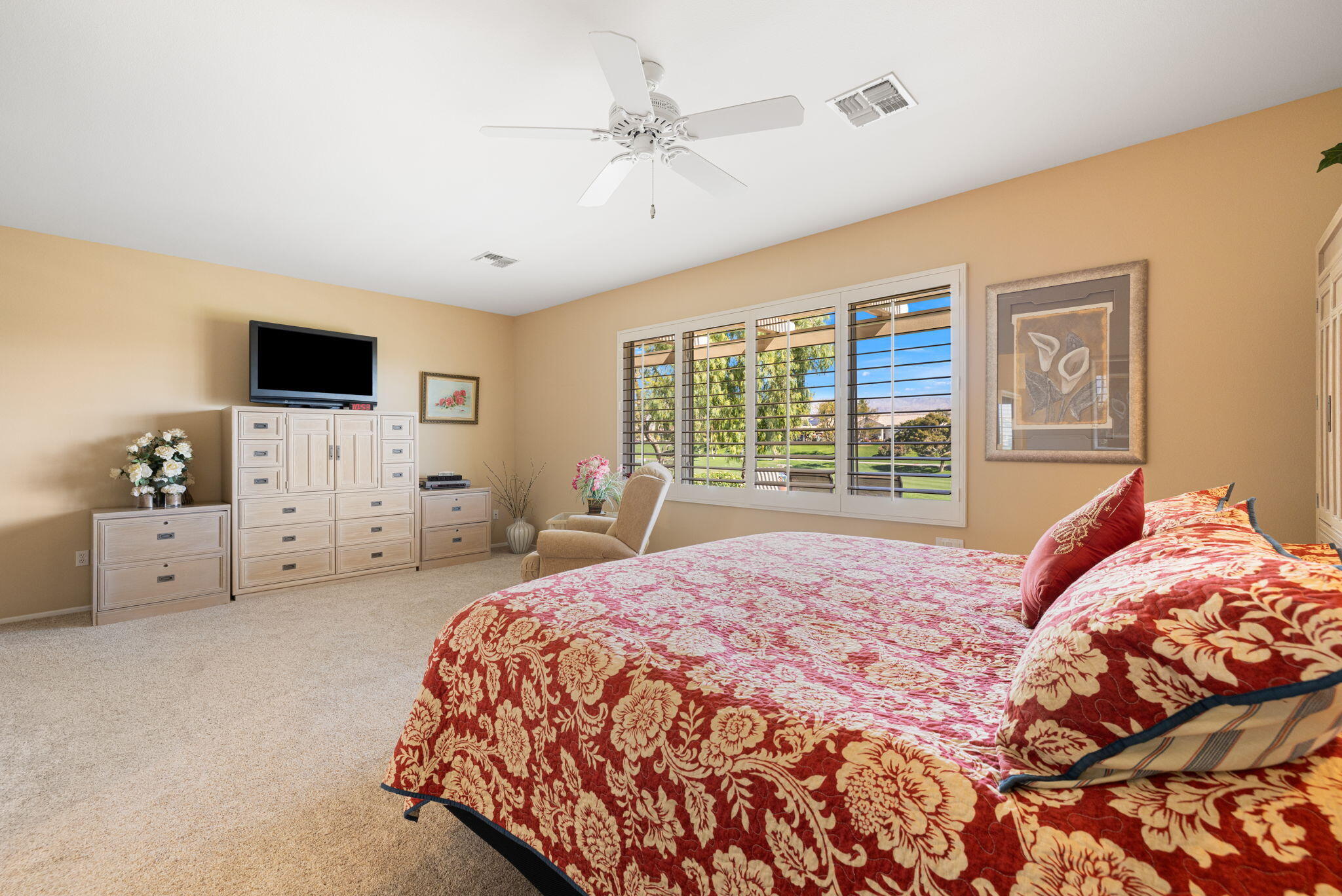 39611 Manorgate Road Palm Desert, CA 92211 - Photo 21 of 45 a bedroom with a large bed and a flat tv screen on dresser