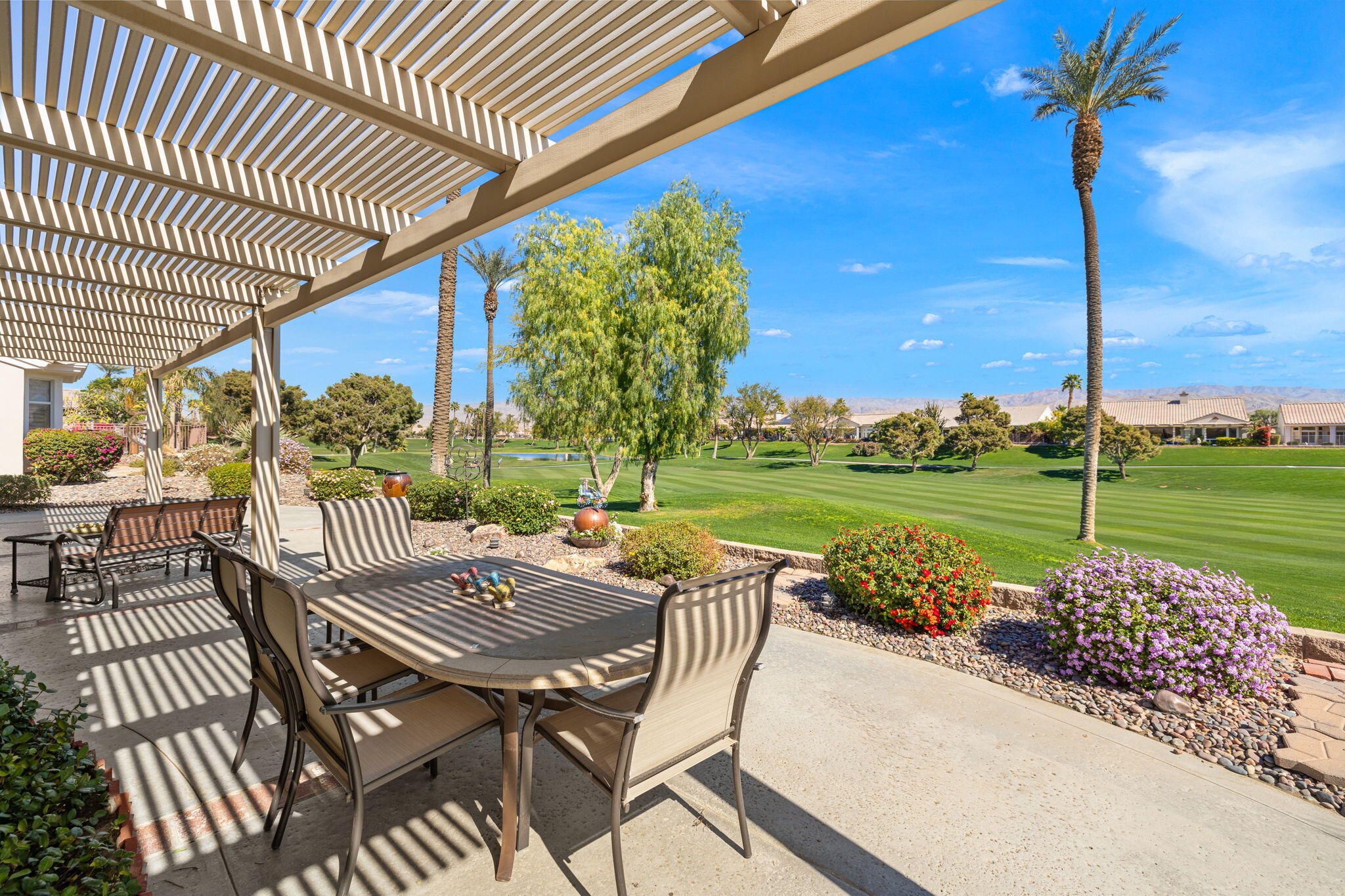 39611 Manorgate Road Palm Desert, CA 92211 - Photo 39 of 45 a view of a patio with table and chairs with wooden floor fence and roof