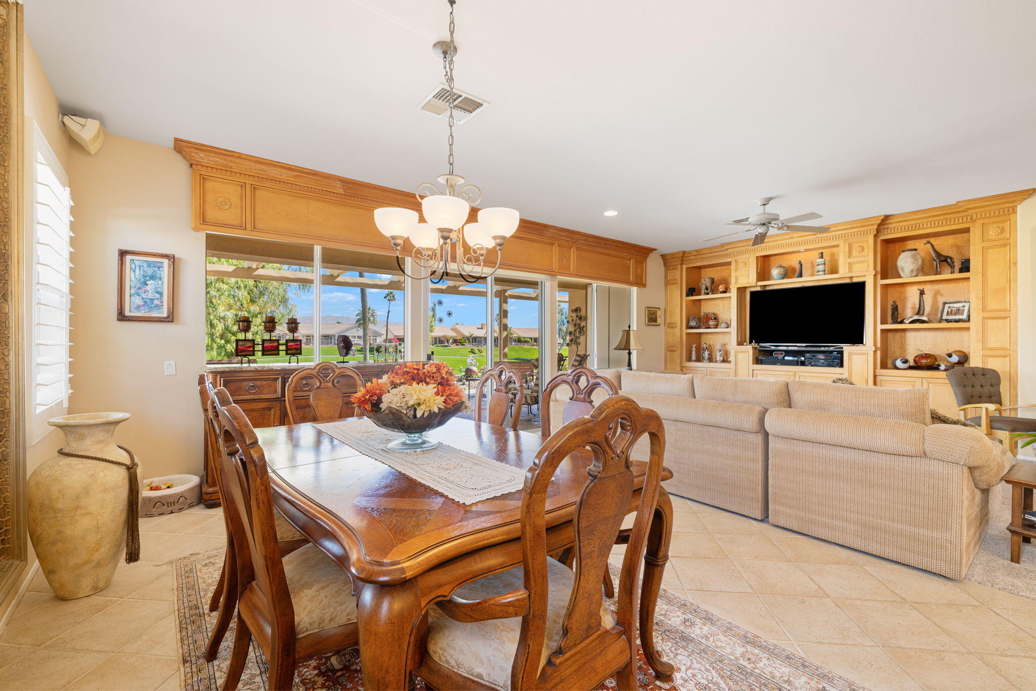 39611 Manorgate Road Palm Desert, CA 92211 - Photo 8 of 45 a dining room with furniture a flat screen tv and a chandelier