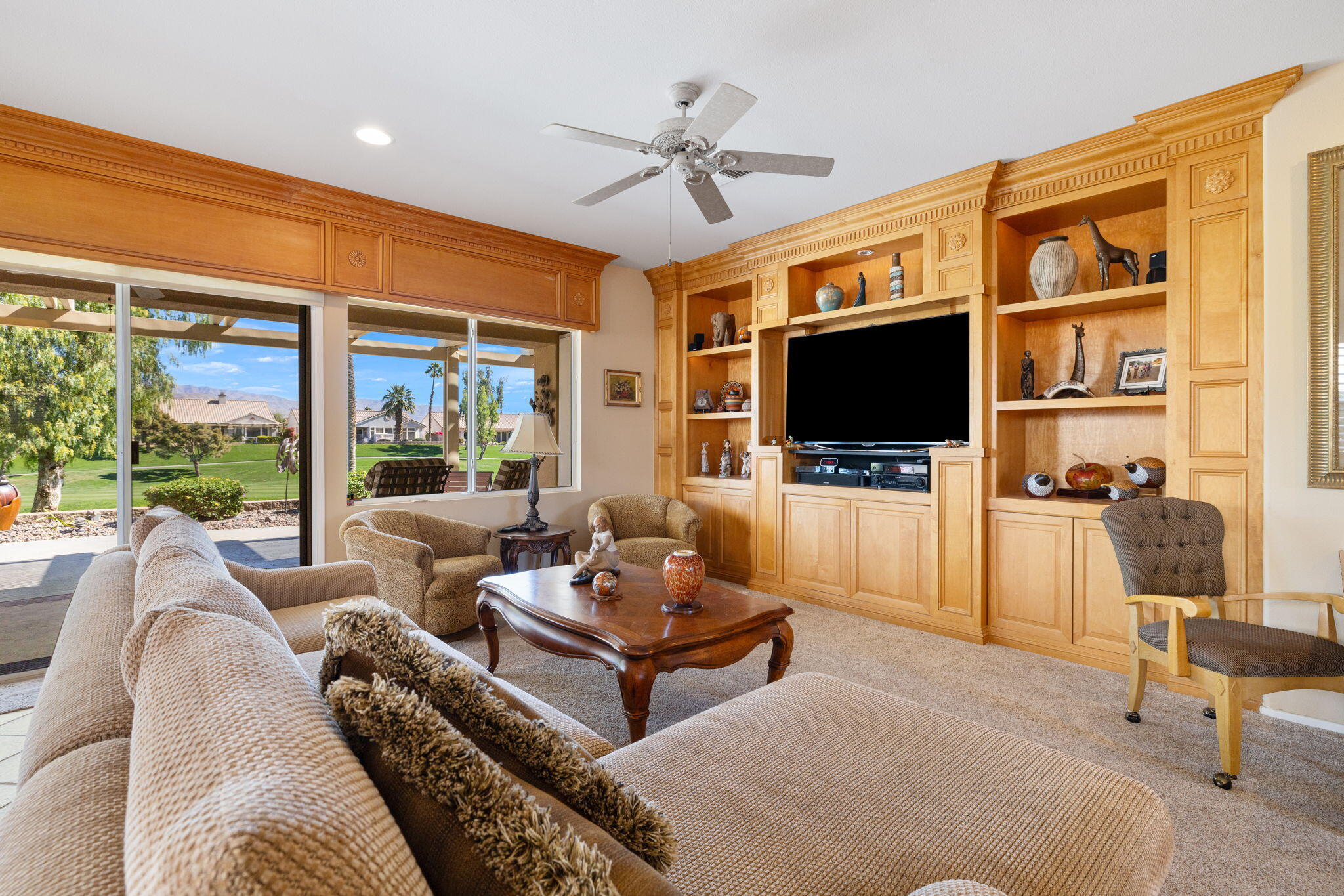 39611 Manorgate Road Palm Desert, CA 92211 - Photo 10 of 45 a living room with furniture a flat screen tv and a floor to ceiling window