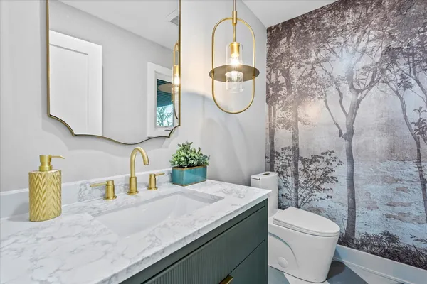 a bathroom with a granite countertop sink a toilet and a mirror