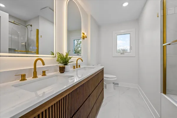 a bathroom with a granite countertop sink a toilet and a mirror